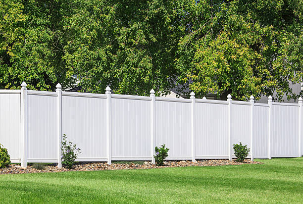 Vinyl fence White vinyl fence running across a homeowners back yard. fence stock pictures, royalty-free photos & images