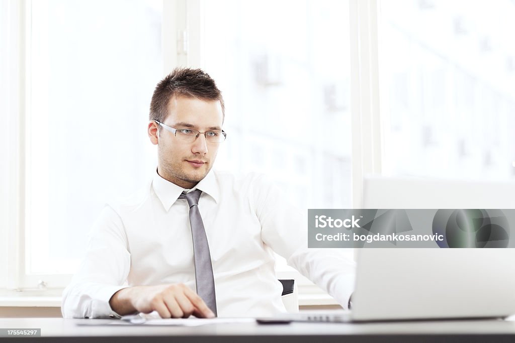 Portrait businessman with a laptop at office Portrait of cheerful, young businessman with a laptop at office. 30-39 Years Stock Photo