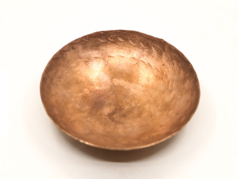 closeup of an empty vintage copper bowl for the kitchen isolated in a white background