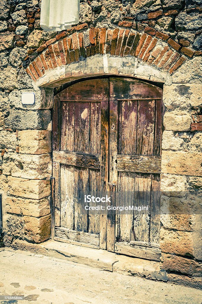 Arruinado puerta de madera en el antiguo pueblo italiano - Foto de stock de Aire libre libre de derechos