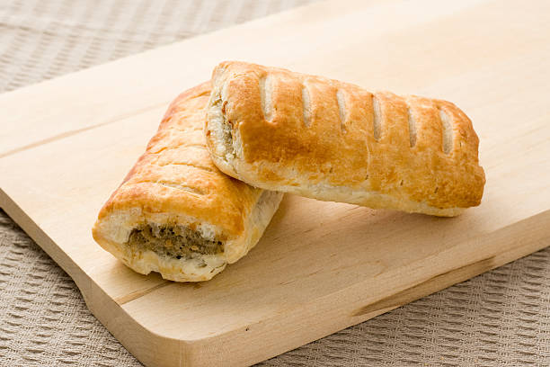 sausage roll snack dolci con carne su una superficie di legno - sausage roll foto e immagini stock