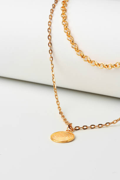 istock Golden chain with pendant on paper background close up 1755464497