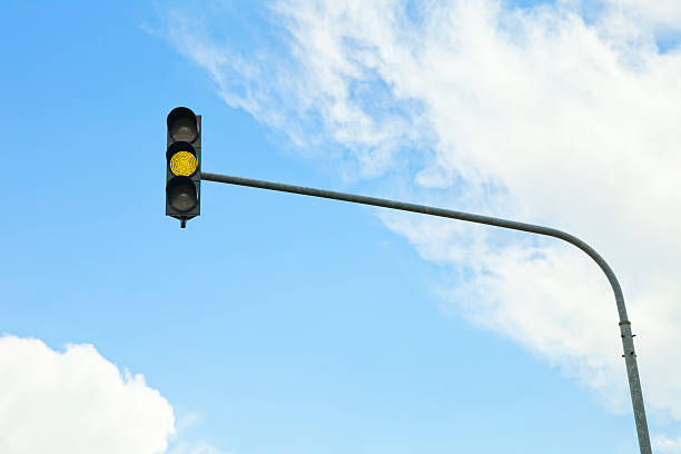 yellow traffic light a traffic light turned yellow with clouds in the backgroundsimilar images: blue yellow lights stock pictures, royalty-free photos & images
