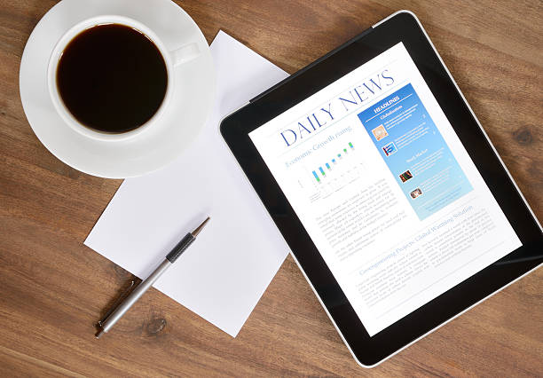 Digital Tablet PC With News On Desk (XXXL) "Desktop with a Tablet PC, which shows the latest news on screen. Fresh Coffee and a Paper to take notes. Nikon D800e. Converted from RAW." company news stock pictures, royalty-free photos & images