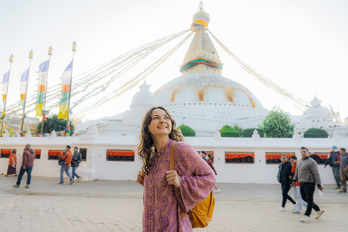 Young Caucasian woman standing on the background of Buddha stupa in Kathmandu