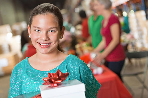 istock A smiling girl is holding a present at a toy drive. 175548266