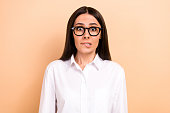 Portrait of young funny astonished nervous girl worried bite lips first business meeting find new job isolated on beige color background