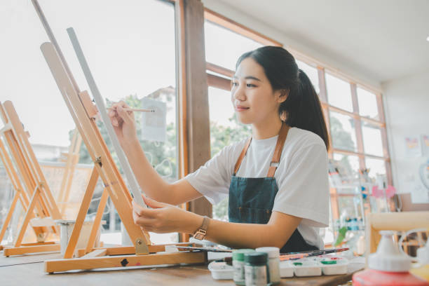 istock Art student drawing with watercolor painting on canvas doing some art projects on studio workshop 1755541655