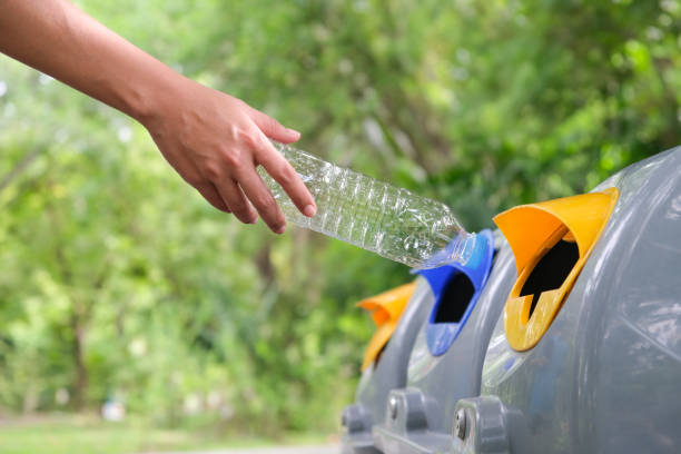 istock Man's hand holding a water bottle and throwing plastic bottles into the trash for disposal. Types of plastic waste and recycling. environmental concept 1755544658