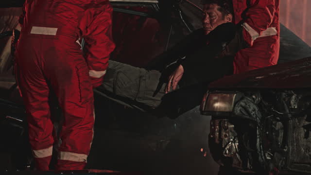 Firefighters helping an injured man in a car