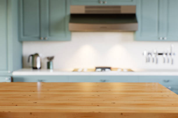 istock Green kitchen with wood countertops and accent island for product display. Empty kitchen countertop with blurred kitchen background with appliances and utensils. 3D rendering. 1755560385