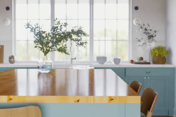 istock Green kitchen with wood countertops and accent island for product display. Empty kitchen countertop with blurred kitchen background with appliances and utensils. 3D rendering. 1755560429