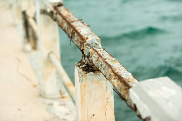 Pier bridge, rusty concrete railing, iron bar, rustic cement, sea background.