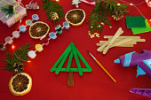 Step by step instruction how to make christmas tree from ice cream sticks. Step 3 glue sticks together. Concept of DIY and kid's creativity.