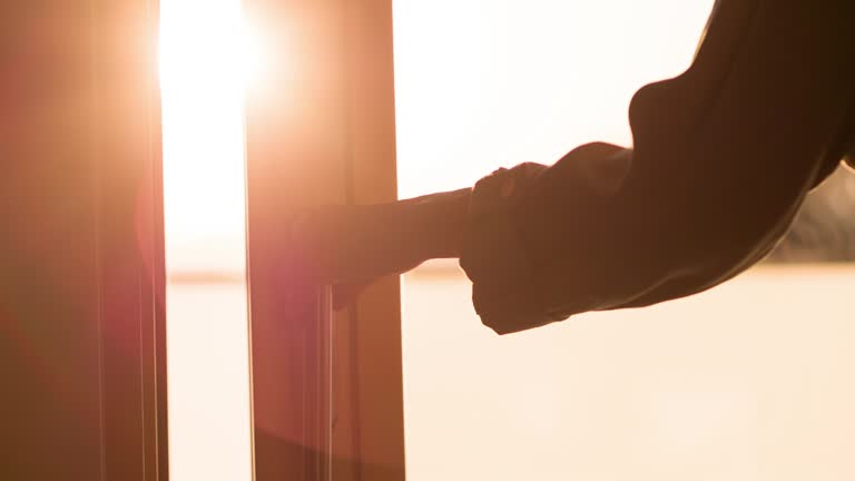 Woman opening sliding window at home to let fresh air in