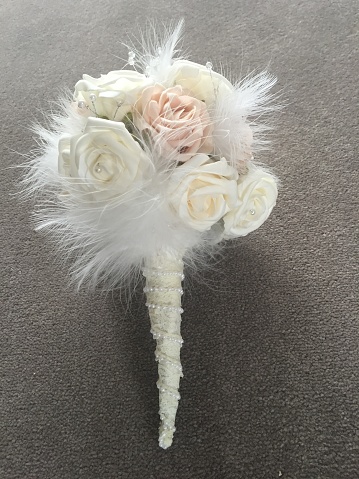 Beautiful Bridal bouquet with artificial flowers, white feathers and Pearls