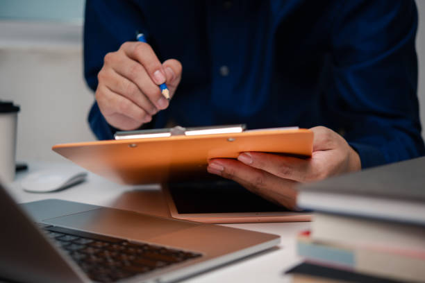 istock man holding clipboard with checklist employee workplace is reviewing documents 1755592845