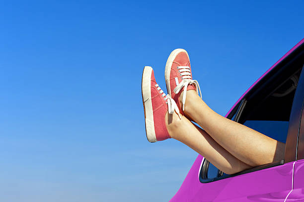 Woman legs out the car windows stock photo