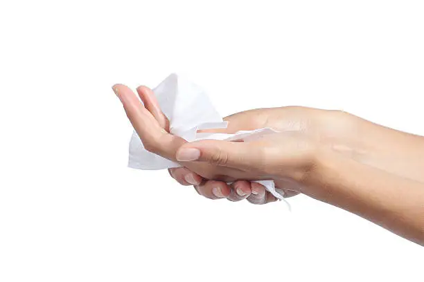 Woman cleaning her hands with a tissue isolated on a white background