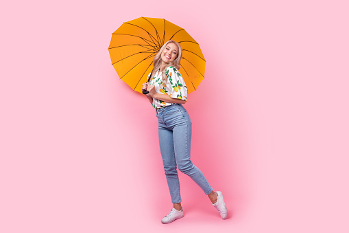 Full body length photo of cute youth girl holding open parasol rainy weather sweet model spring storm isolated on pink color background.