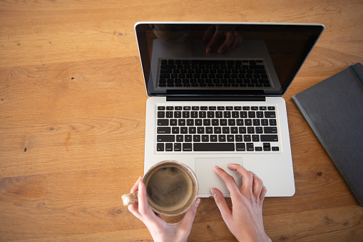 laptop and coffee in hand