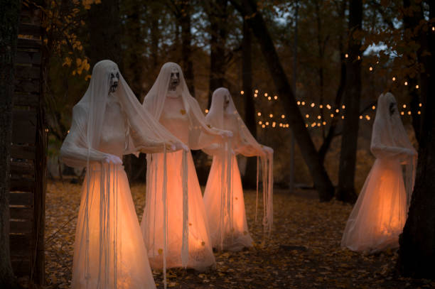 istock Halloween decorations, ghosts in white garments illuminated in the park 1755616448