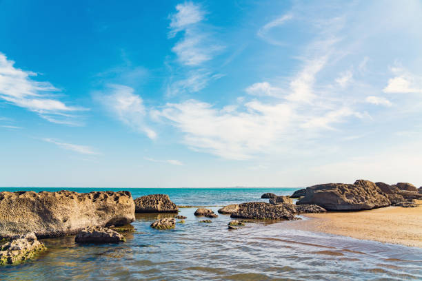 Rocky seashore and beautiful clouds on the blue sky