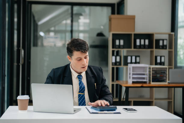 istock Young business man working at office with laptop, tablet and taking notes on the paper. 1755624649
