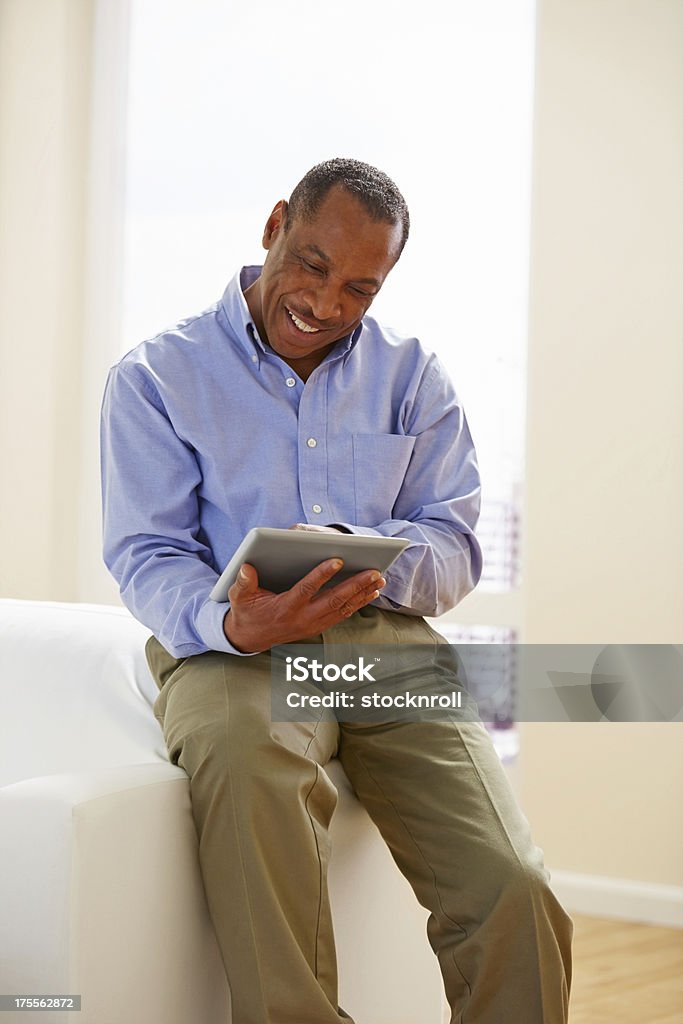 Glücklicher Reifer Mann sitzen auf der Couch mit tablet pc - Lizenzfrei Männer Stock-Foto