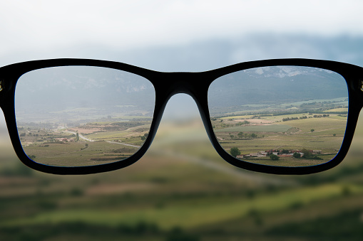 Eyeglasses focusing a beautiful landscape - myopia concept