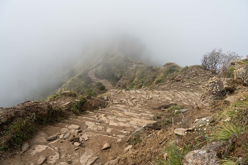 A majestic view of a mountain range with a stone staircase winding up the side of the incline