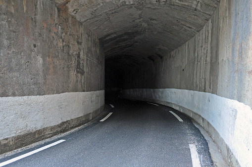 Narrow asphalt road for cars in a concrete tunnel in the south of France in the mountains.