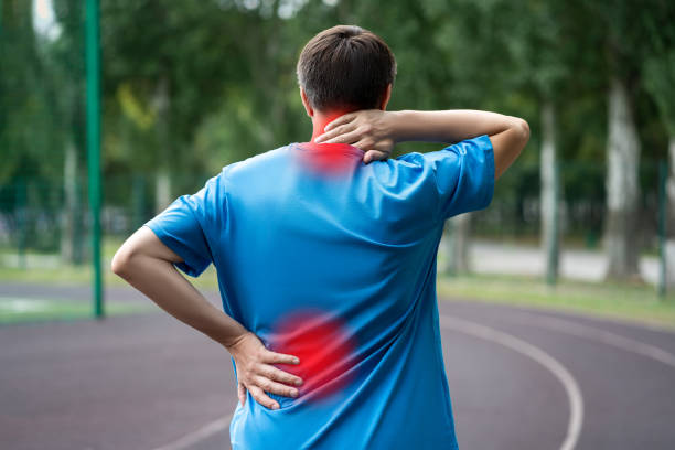 Back pain, athletic man with backache on a running track after workout Back pain, athletic man with backache on a running track after workout, health problems concept kyphosis stock pictures, royalty-free photos & images