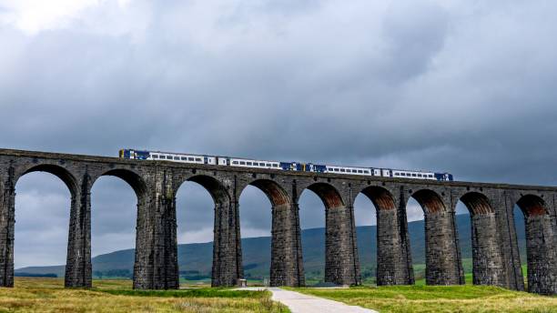 istock a train on the top of a bridge under a cloudy sky 1755650179