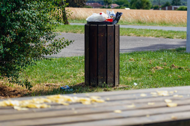 istock Public trash can in a park filled with overflowing trash 1755661220