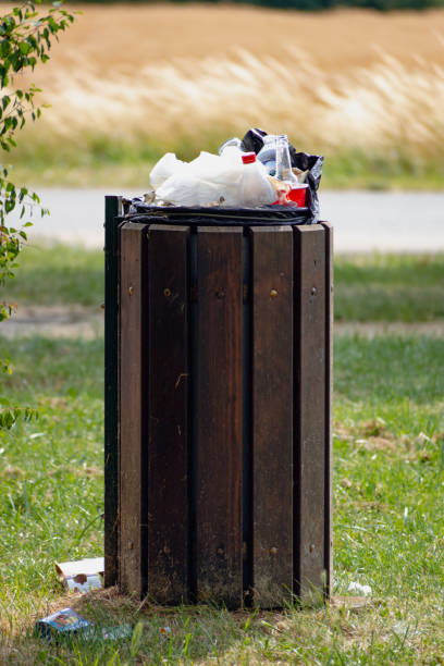 istock Public trash can in a park filled with overflowing trash 1755661250