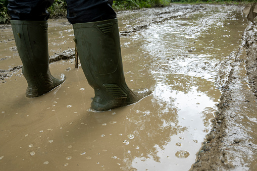 Man wearing boots and walking in mud