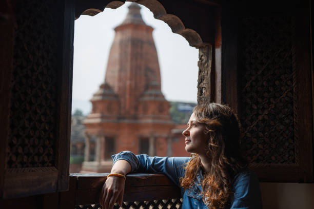 femme assise sur un balcon surplombant la place durbar de bhaktapur - durbar square photos et images de collection