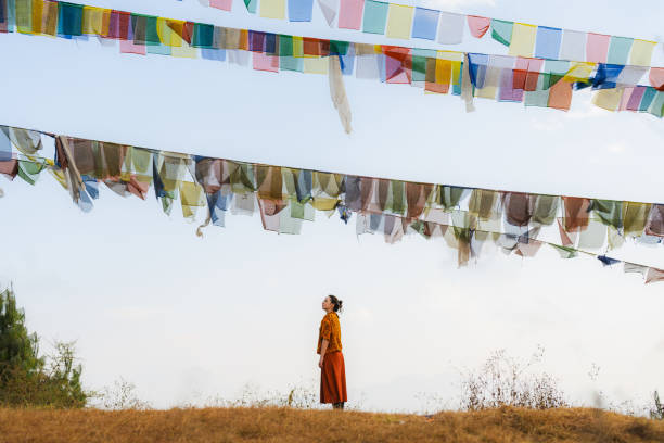 woman on the background of tibetan prayer flags and sky - tibetan temple imagens e fotografias de stock