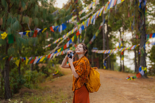 Young Caucasian woman  photographing  Tibetan prayer flags