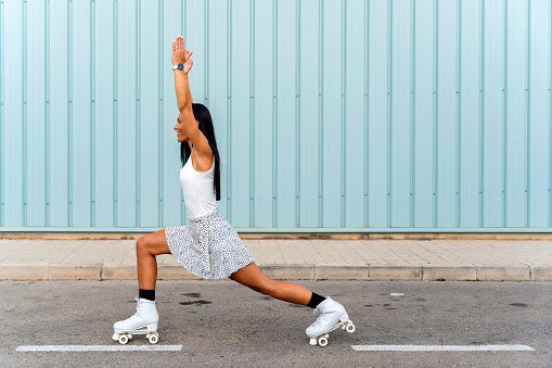 Middle aged skater woman with roller skates, doing yoga poses.