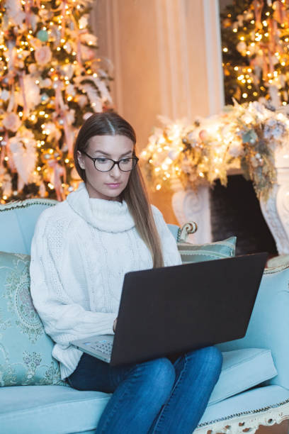 jolie jeune femme aux cheveux bruns utilisant un ordinateur portable à la maison. concept de vacances de noël et du nouvel an - women computer home interior brown hair photos et images de collection