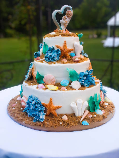 istock Tiered wedding cake with beach theme, adorned with starfish, seashells and coral 1755733648