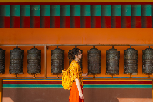 Woman using prayer wheels in Tibetan monastery  in Nepal
