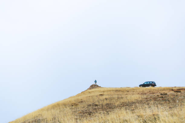 A photographer takes pictures on a trip with their own car.