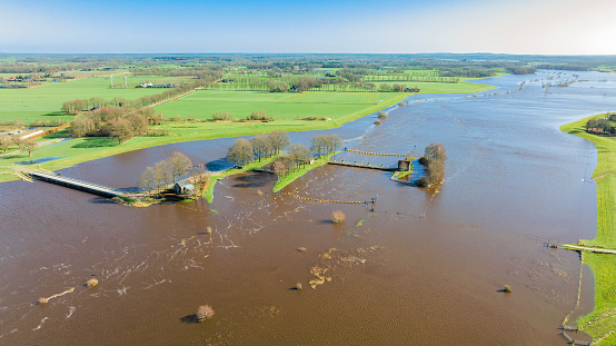 High water level in the river Vecht at the Vechterweerd weir in the Dutch Vechtdal region in Overijssel, The Netherlands. The river is overflowing on the floodplains after heavy rainfal upstream in The Netherlands and Germany during storm Eunice and Franklin in February 2022.