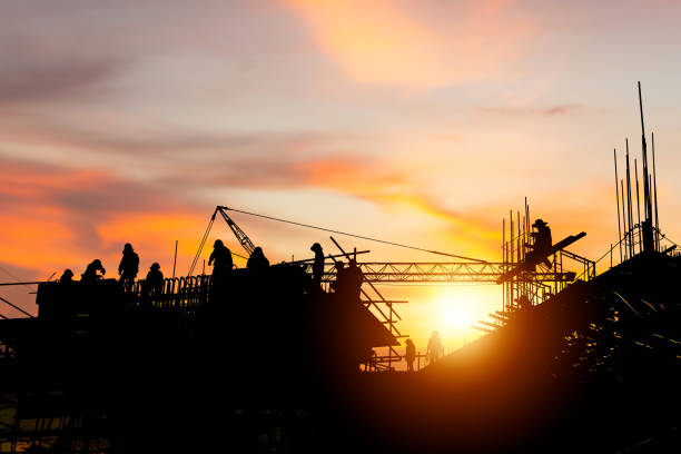 istock Silhouette of Engineer and worker checking project at building site background, construction site at sunset in evening time 1755757755