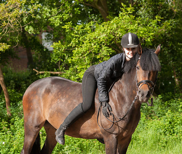 Garota senta-se em seu cavalo - foto de acervo