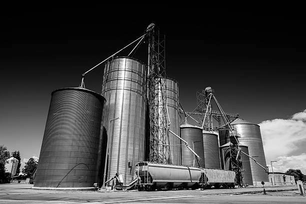 Industrial Grain Elevators and Freight Trains in Idaho This is a black and white photograph shot with a wide angle lens of industrial, metal grain elevators and freight trains in Ashton, Idaho.  ashton idaho photos stock pictures, royalty-free photos & images