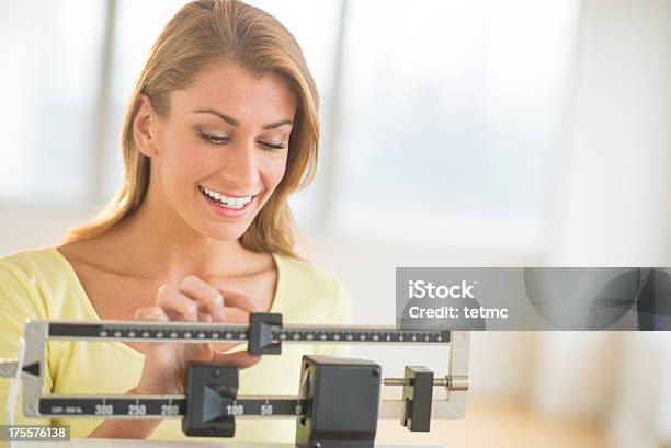 Woman Weighing Herself On Balance Scale Stock Photo - Download Image Now - Weight Scale, Happiness, Dieting